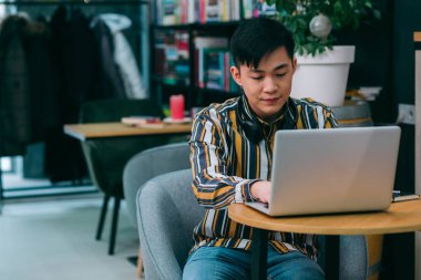 Bilgisayarın önünde oturup ekrana bakarken kaşlarını çatmaktan yorgun düşmüş ciddi bir öğrenci.