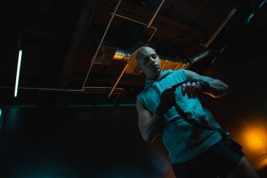 Sakin genç adam boks bandajı bağlarken eline bakıyor. Web sitesi afişi