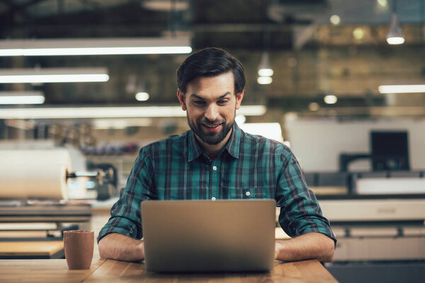 Positive man with a laptop looking enthusiastic while working on it