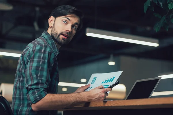 Nieuwsgierige Man Aan Tafel Aan Het Werk Met Graphics Terug — Stockfoto