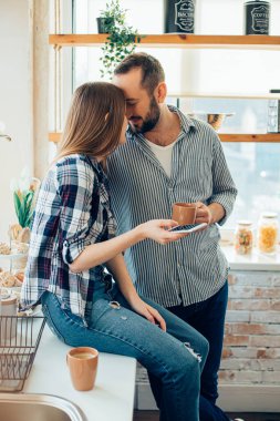 Genç adam ve kadın alınlarını birleştirip sevimli görünüyorlar.