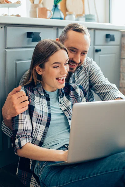 남자와 여자가 미소짓고 부엌에 노트북 화면을 — 스톡 사진