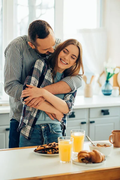 Bela Senhora Sorrindo Enquanto Namorado Abraça Pequeno Almoço Saboroso Mesa — Fotografia de Stock