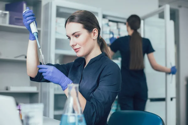 Rolig Ung Kvinde Iført Gummihandsker Ved Hjælp Dråbetæller Med Reagensglas - Stock-foto