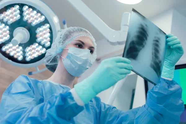 Ellerinde göğüs röntgeni olan deneyimli bir doktor.