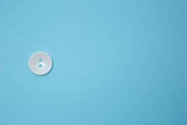 Mavi arkaplanda küçük bir düğmenin üst görünümü. Boşluğu sağ tarafa kopyala