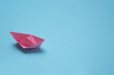 Mavi arka planda pembe kağıt gemi olan deniz konsepti. Şablon pankartı