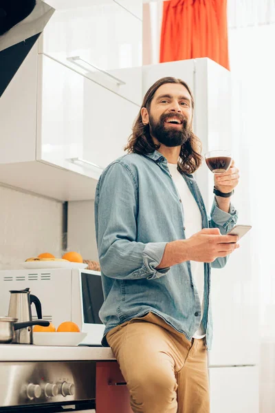 Entzückter Gutaussehender Mann Der Mit Kaffee Und Smartphone Der Küche — Stockfoto