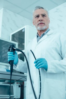 Klinikte elinde endoskopla duran deneyimli bir doktor.