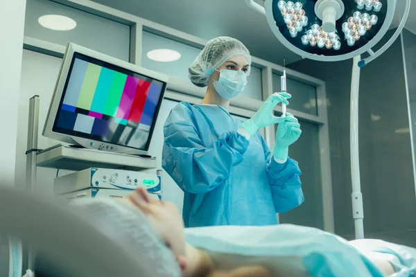 Operationsschwester Steht Neben Der Patientin Und Betrachtet Die Spritze — Stockfoto
