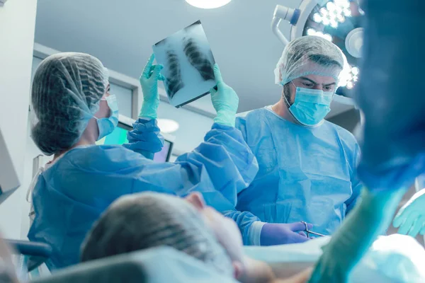 Cirujano Cerca Del Paciente Frunciendo Ceño Una Enfermera Mirando Radiografía — Foto de Stock