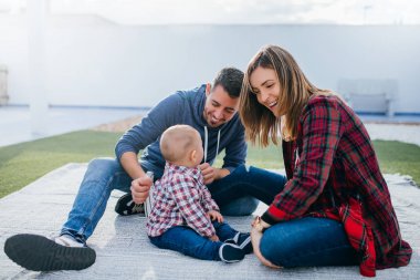 mutlu aile anne ve baba bir bebekle evde oynarken