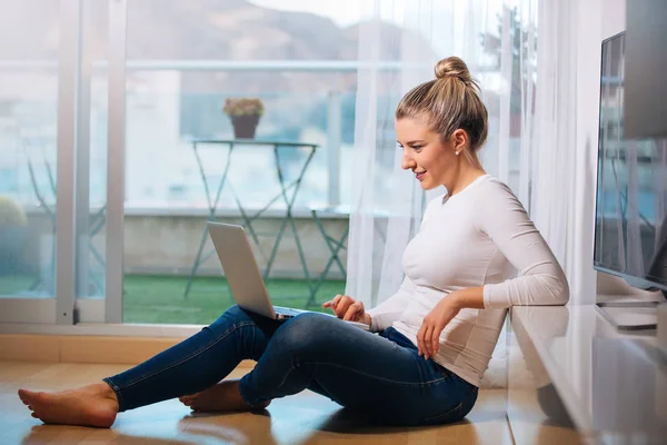 Relajado sonriendo descalza mujer sentada en el suelo mirando h — Foto de Stock