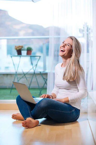 Relajado sonriendo descalza mujer sentada en el suelo mirando h — Foto de Stock