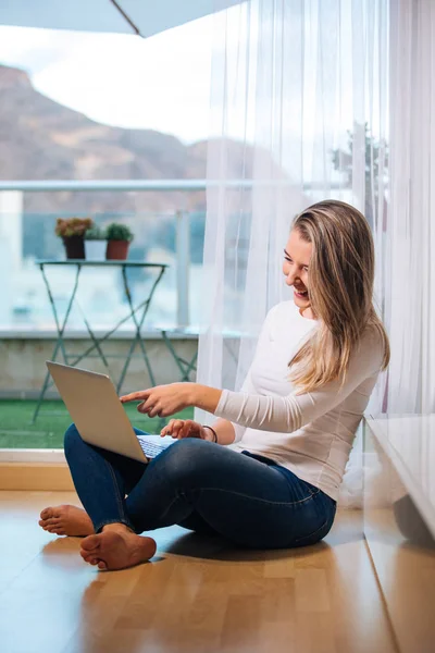 Relajado sonriendo descalza mujer sentada en el suelo mirando h — Foto de Stock