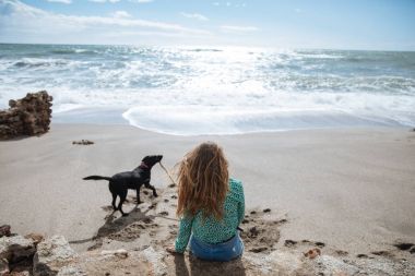 mutlu kadın köpeğiyle oynamaya Sahilde yürüyüş
