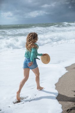 Kumsalda yürüyen mutlu kadın