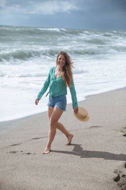 Kumsalda yürüyen mutlu kadın