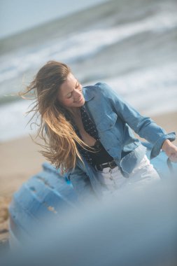 mutlu genç kadın oturuyor ve o mavi teknede önünde poz