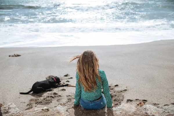 Wanita bahagia berjalan di pantai bermain dengan anjingnya — Stok Foto