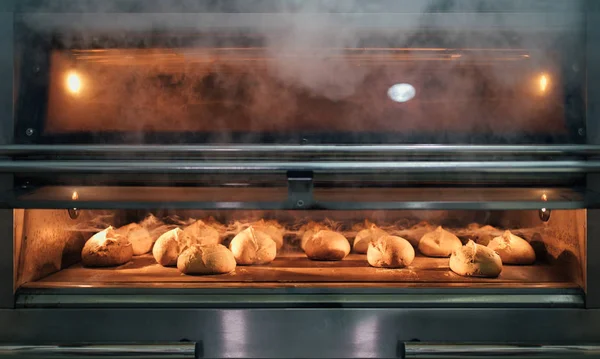 Hornear pan dentro de un horno en una panadería —  Fotos de Stock