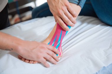 Fiziksel terapist hastanın yürüyerek kinesio bant yerleştirme