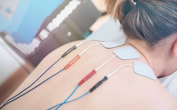 Physical therapist positioning electrodes for high back muscle t