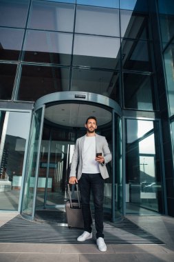 Otel lobisinden yürüyüş iş adamı. Uzunluk portre tam