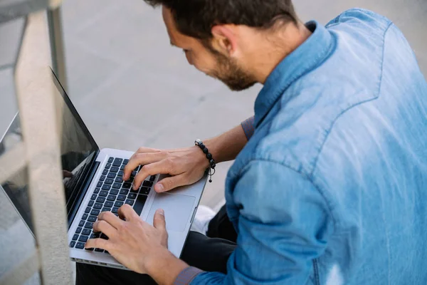 Nahaufnahme eines jungen Mannes, der in seinem Laptop arbeitet. Unternehmen — Stockfoto