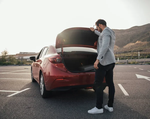 Homem viajante colocando mala no porta-malas do carro — Fotografia de Stock