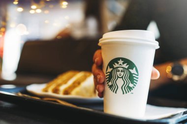New York, Usa - 5 Kasım 2019 Starbucks kahvesinde havuçlu kek içen kadın. Starbucks 61 ülkede 20.000 'den fazla mağazası olan dünyanın en büyük kahve evi.