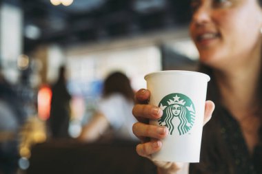 New York, Usa - 5 Kasım 2019 Starbucks kahve dükkanında havuçlu kek içen bir kadının yakın çekimi. Starbucks, 20.000 'den fazla mağazası olan dünyanın en büyük kahve dükkânı.