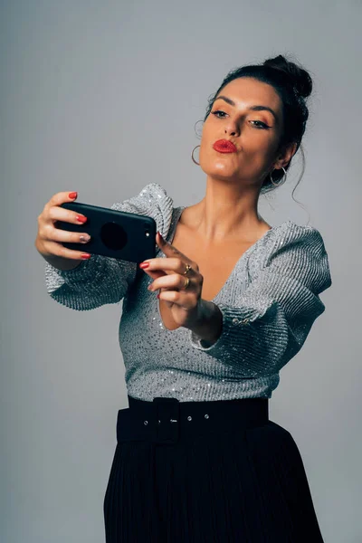 Retrato de uma mulher muito jovem vestida para festa fazendo uma selfie com smartphone . — Fotografia de Stock