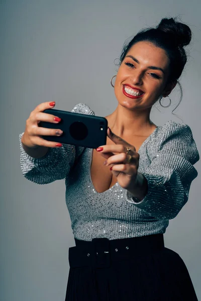 Retrato de uma mulher muito jovem vestida para festa fazendo uma selfie com smartphone . — Fotografia de Stock