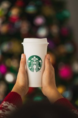 New York, Usa - 24 Kasım 2019: Bir Yılbaşı Ağacı Arkaplanında Uzun Starbucks Kupası Tutan Kadın.