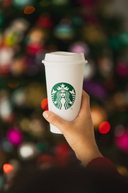 New York, Usa - 24 Kasım 2019: Bir Yılbaşı Ağacı Arkaplanında Uzun Starbucks Kupası Tutan Kadın.