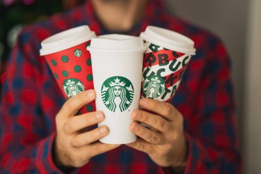New York, Usa - 8 Aralık 2019: Üç Uzun Starbucks Kupası 'nı elinde tutan adama yakın çekim. 2019 Noel Tatili için Bir Orijinal Kupa ve İki Tasarım.