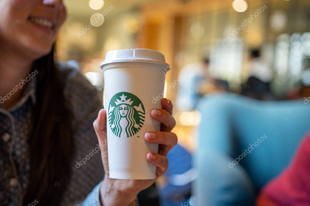 New York, USA - December 1, 2019 : Business Caucasian Woman Taking a Break with a Tall Cup of Starbucks Coffee in Starbucks Coffee Shop.