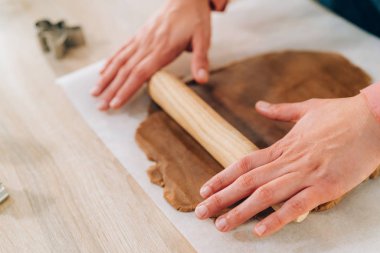 Ho 'da kurabiye yapan genç bir kadına yaklaş ve hamur yoğur.