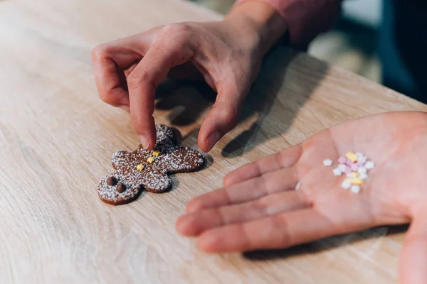 Frau Hand verziert Lebkuchen Mann Plätzchen. Weihnachtsplätzchen selbst gebacken. — Stockfoto