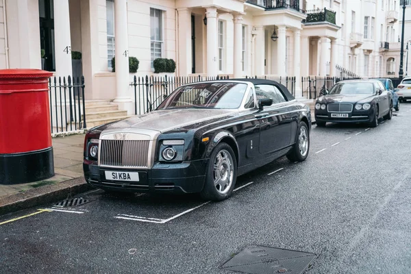 LONDRA, REGNO UNITO - 02 gennaio 2020: Primo piano del logo Rolls Royce su un'auto grigia con gocce d'acqua. Rolls Royce rimane un simbolo di una macchina di lusso . — Foto Stock
