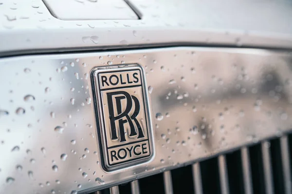 LONDRA, REGNO UNITO - 02 gennaio 2020: Primo piano del logo Rolls Royce su un'auto grigia con gocce d'acqua. Rolls Royce rimane un simbolo di una macchina di lusso . — Foto Stock