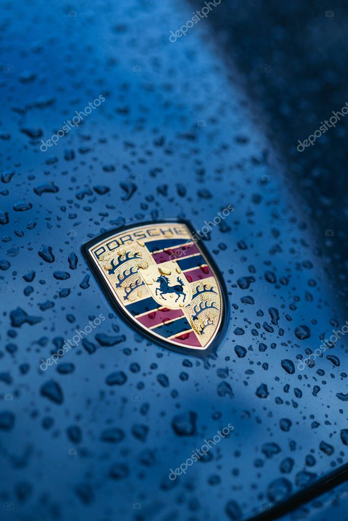 LONDON, UNITED KINGDOM - January 02, 2020: Porsche Logo Close Up on a black car with rain drops. Ferdinand Porsche founded the company in 1931 with main offices in the city center.