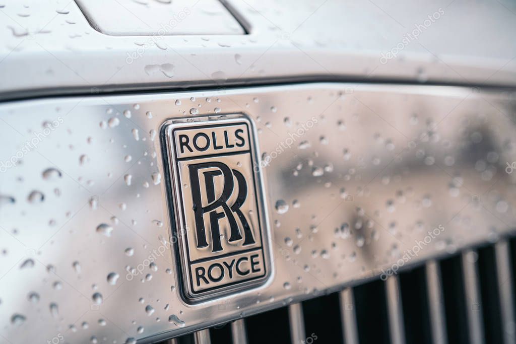 LONDON, UNITED KINGDOM - January 02, 2020: A close-up of the Rolls Royce logo on a grey car with drops of water. Rolls Royce remains a symbol of a luxurious car.