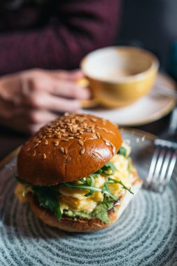 Haşlanmış yumurtalı sebzeli burger ve kremalı çörek. Hayat tarzında sağlıklı kahvaltı kavramı.