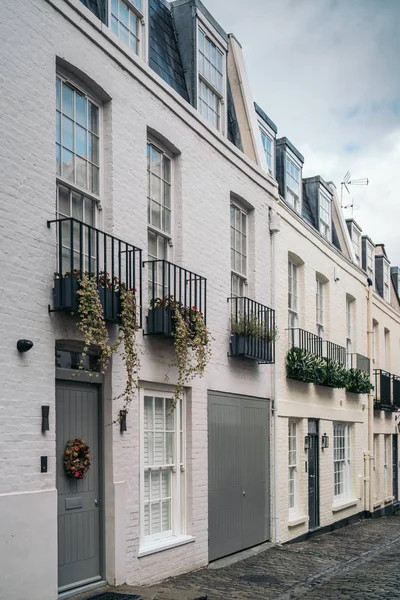 London street of terraced houses without parked cars. Exclusive mews with colored small houses in Chelsea, a wealthy borough of London — Stock Photo, Image