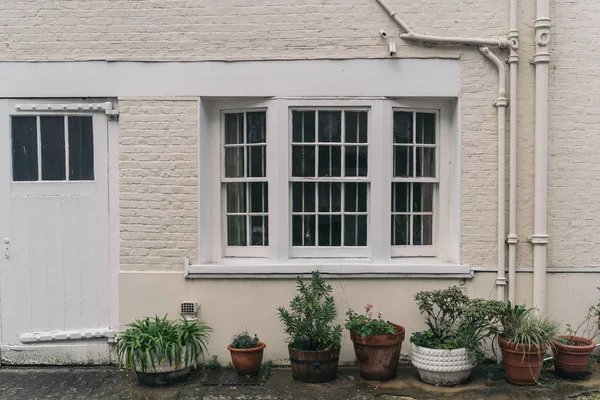 Szép ablakok vagy erkélyek exkluzív mews fehér kis házak Chelsea, gazdag kerület London. — Stock Fotó