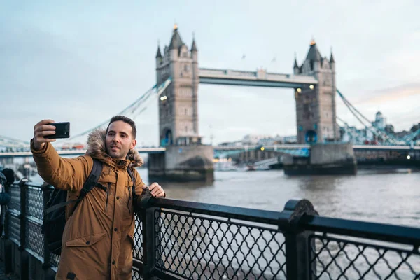 Młody Człowiek Robi Zdjęcie Smartfonem Tower Bridge Londynie Słoneczny Zimowy — Zdjęcie stockowe