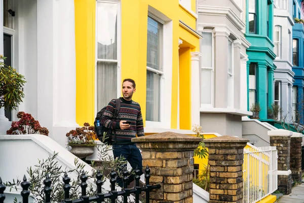 Fiatalember Elhagyja Házát Használja Okos Mobilját Színes Házakkal Portobello Streeten — Stock Fotó