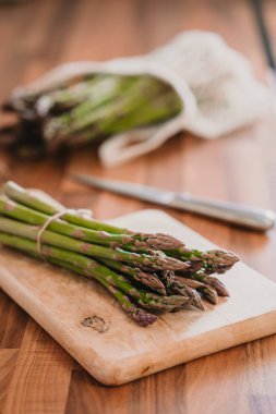 Tahta masada bir demet taze kuşkonmaz.
